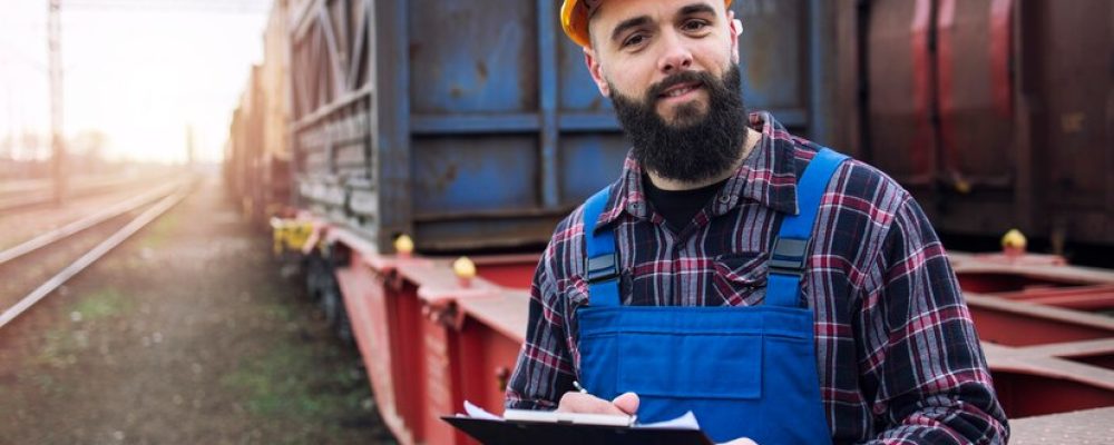 portrait-shipping-worker-holding-clipboard-dispatching-cargo-containers-via-railroad_342744-756